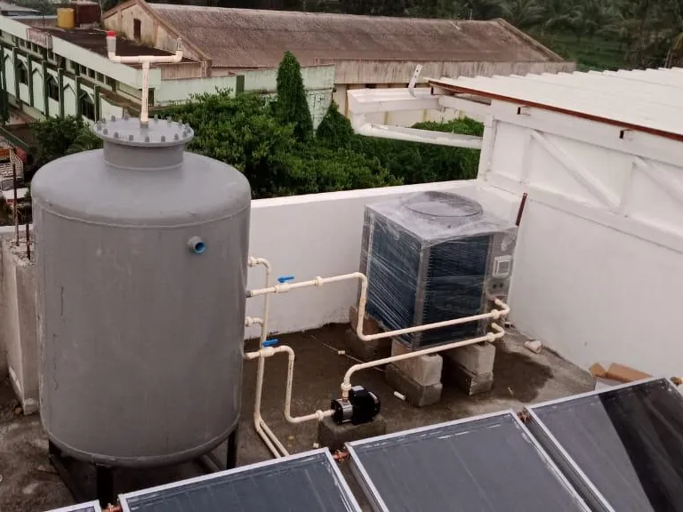 Commercial heat pump, pump and pressure tank with flat plate collectors on an institutional rooftop