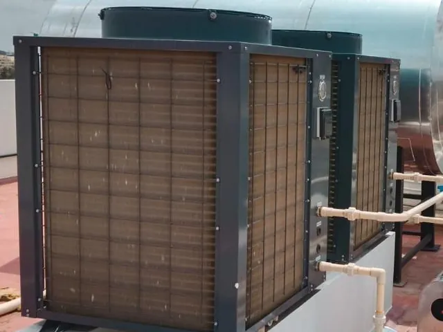 Twin commercial heat pumps piped to a horizontal stainless storage tank