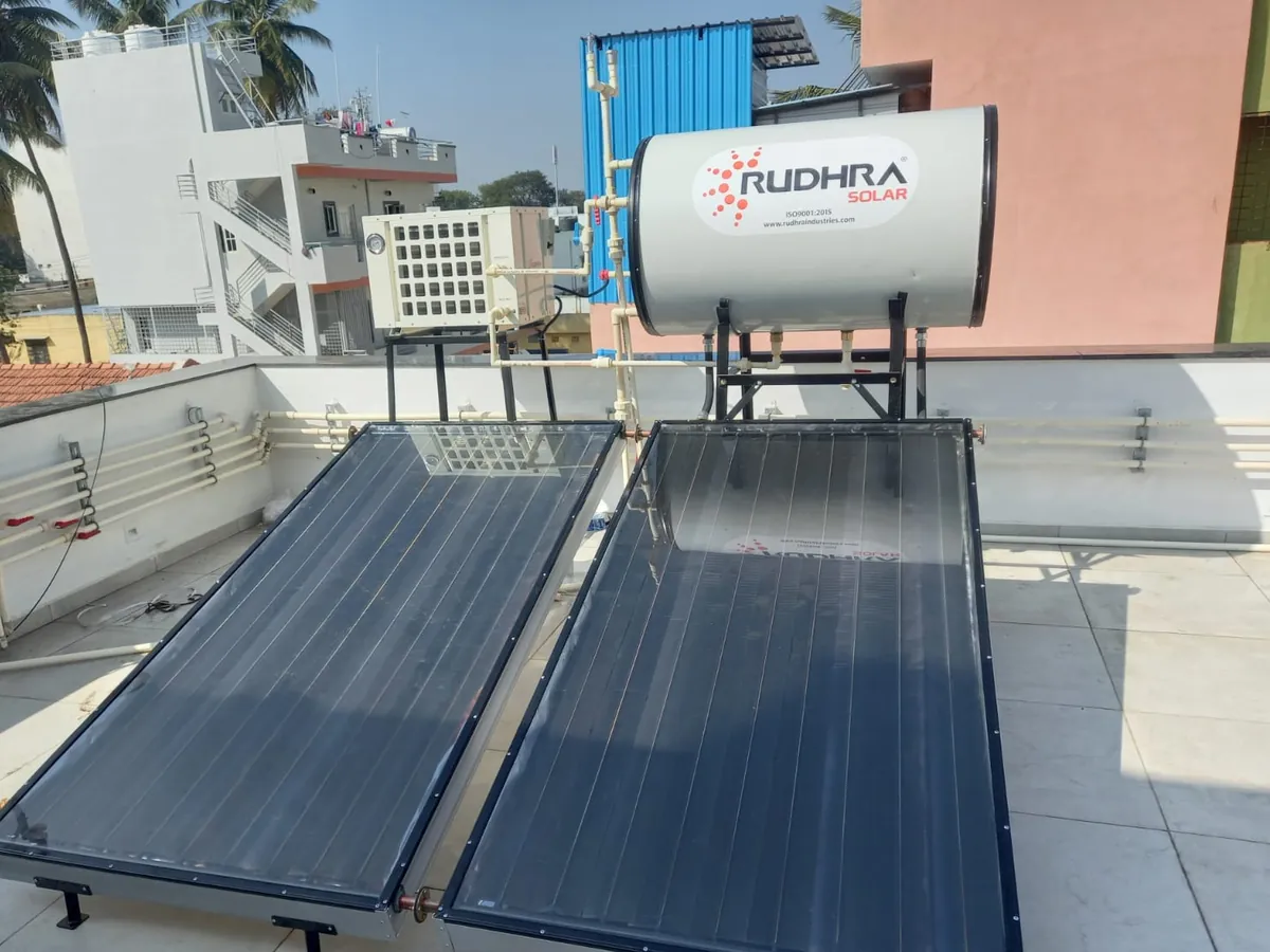 Domestic heat pump paired with a Rudhra Solar water heater on a city terrace
