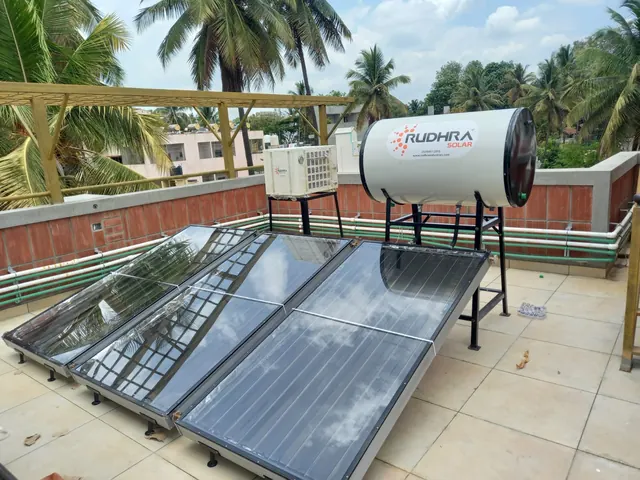 Domestic heat pump with a Rudhra Solar tank and three flat plate collectors on a villa terrace