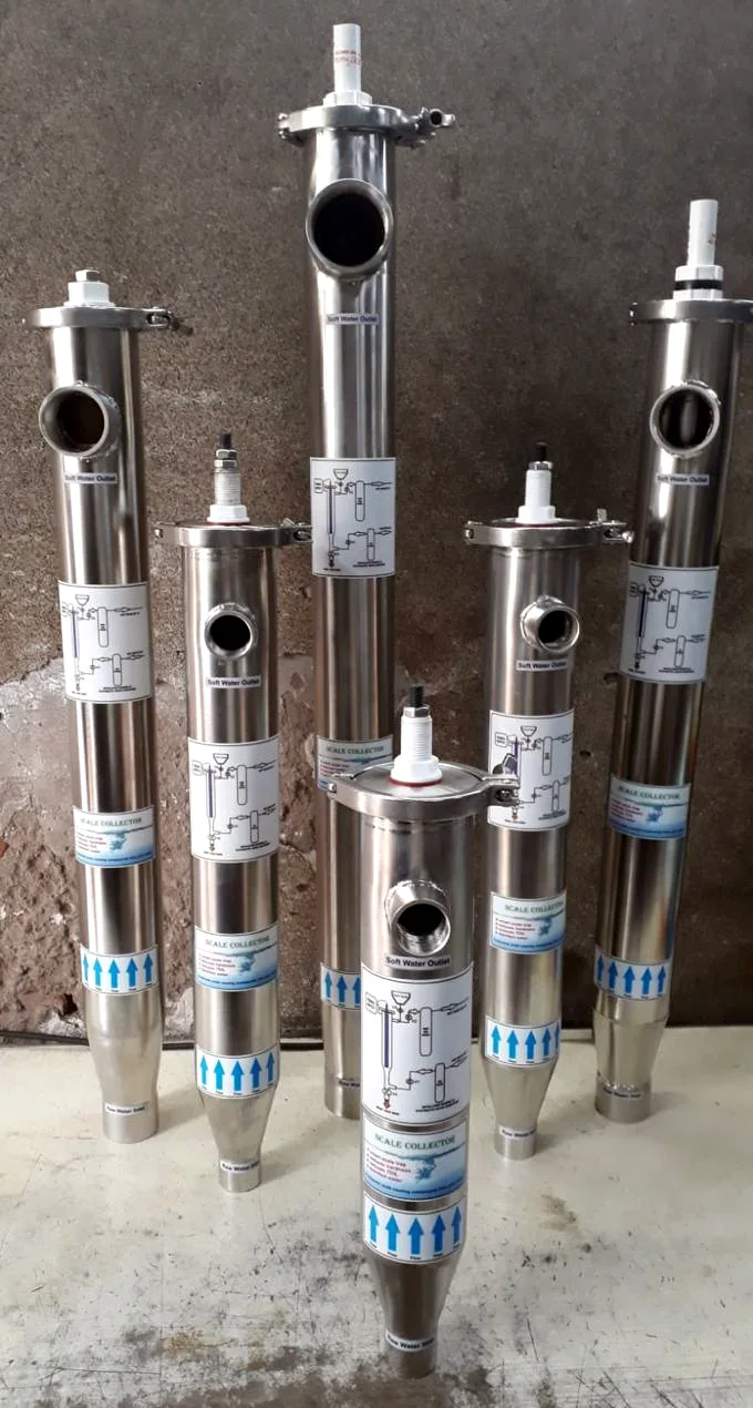 Six Deur iSoft units of different lengths in stainless steel, each with an inlet at the base and a soft water outlet near the top